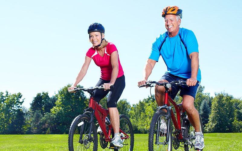 Older man and woman riding bikes together