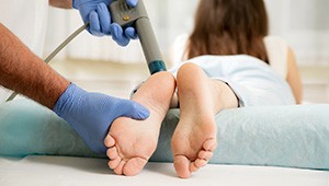 patient getting shockwave therapy on her feet