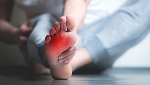 person holding their foot in pain